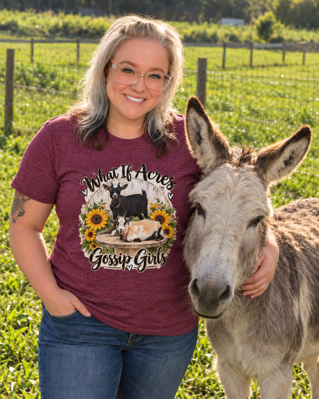 What If Acres Gossip Girls Heather Maroon short-sleeve shirt beside the donkey on the farm.